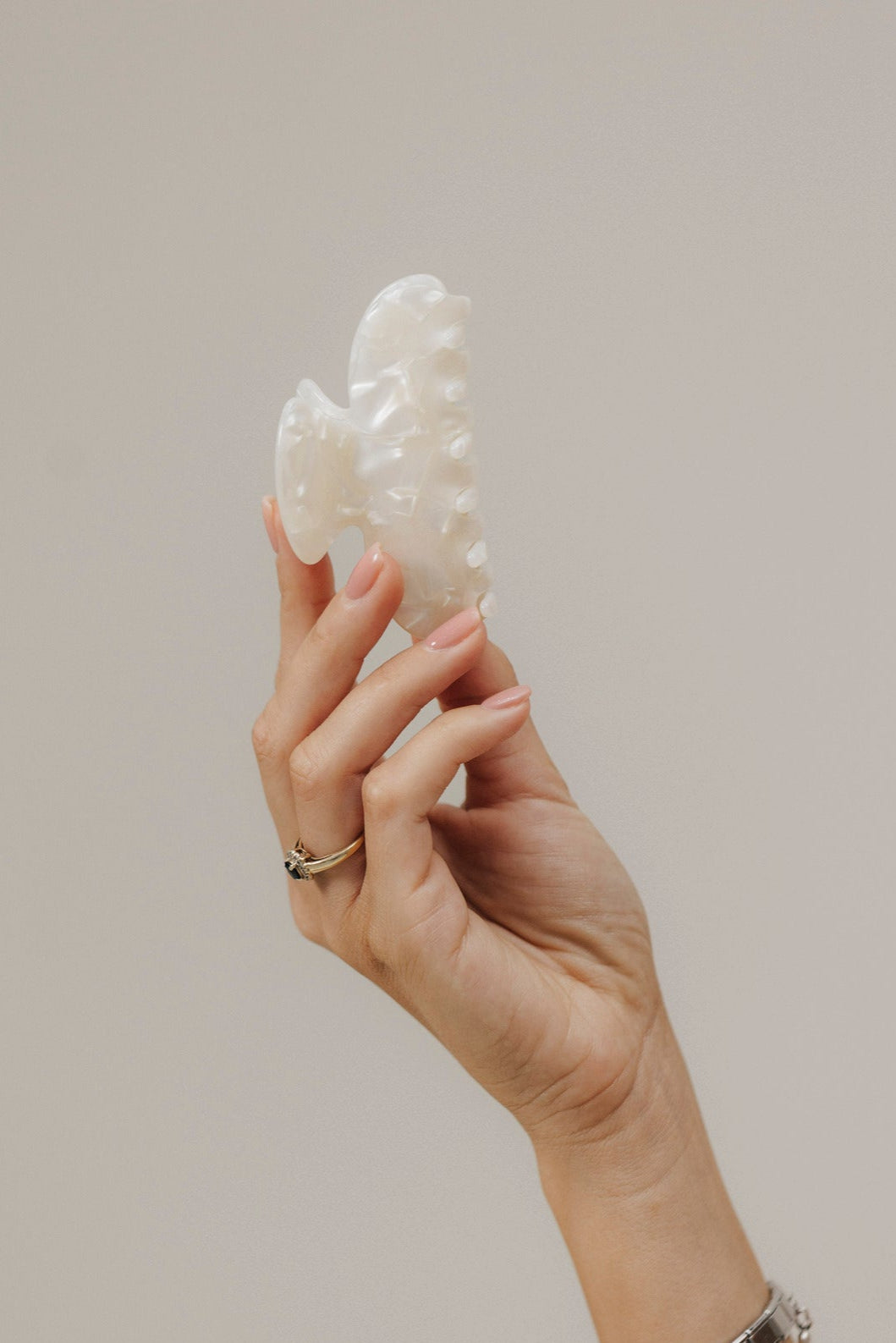 Unsere Haarklammer in Shell (8,5 cm) aus Bio-Acetat – stilvoll in der Hand präsentiert, Fokus auf die strukturierte Oberfläche.