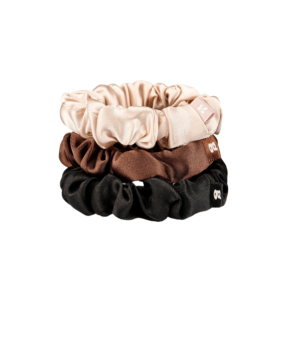3 Seiden Scrunchies in beige, braun und schwarz übereinander gelegt.