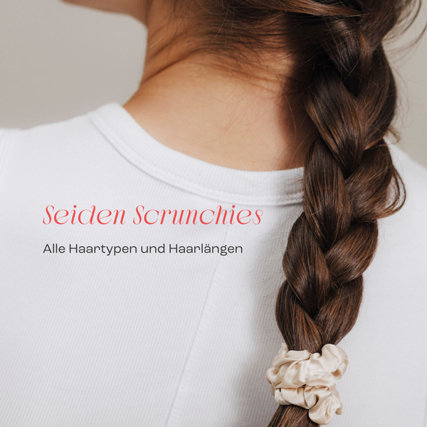 Nahaufnahme eines geflochtenen Zopfs, fixiert mit einem beigefarbenen Seiden-Scrunchie. Person trägt ein weißes Oberteil. Darüber der Schriftzug ‚Seiden Scrunchies – Alle Haartypen und Haarlängen‘.