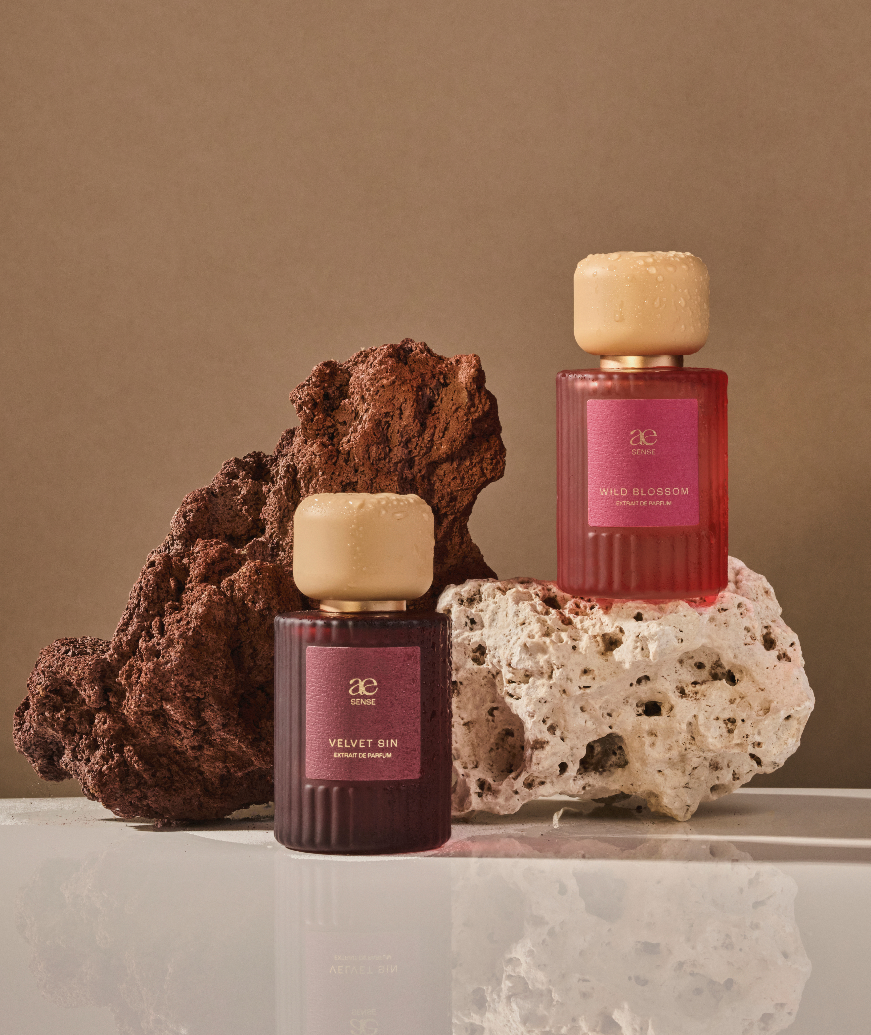 Beide Düfte mit beigen Hintergrund und zwei Steine.