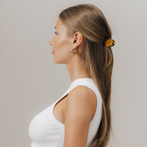 Profilansicht einer Frau mit glatten, offenen Haaren, zurückgesteckt mit unserer Mini-Haarklammer in Tortoise (3,5 cm) – elegant und alltagstauglich gestylt.