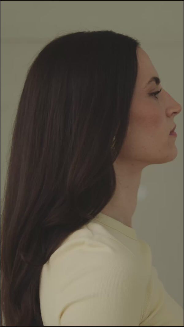 Video mit einer Frau mit dunklen Haaren wird von der Seite gefilmt, während sie sich die Haare mit unserem beigen Maulbeerseidenscrunchie zubindet.