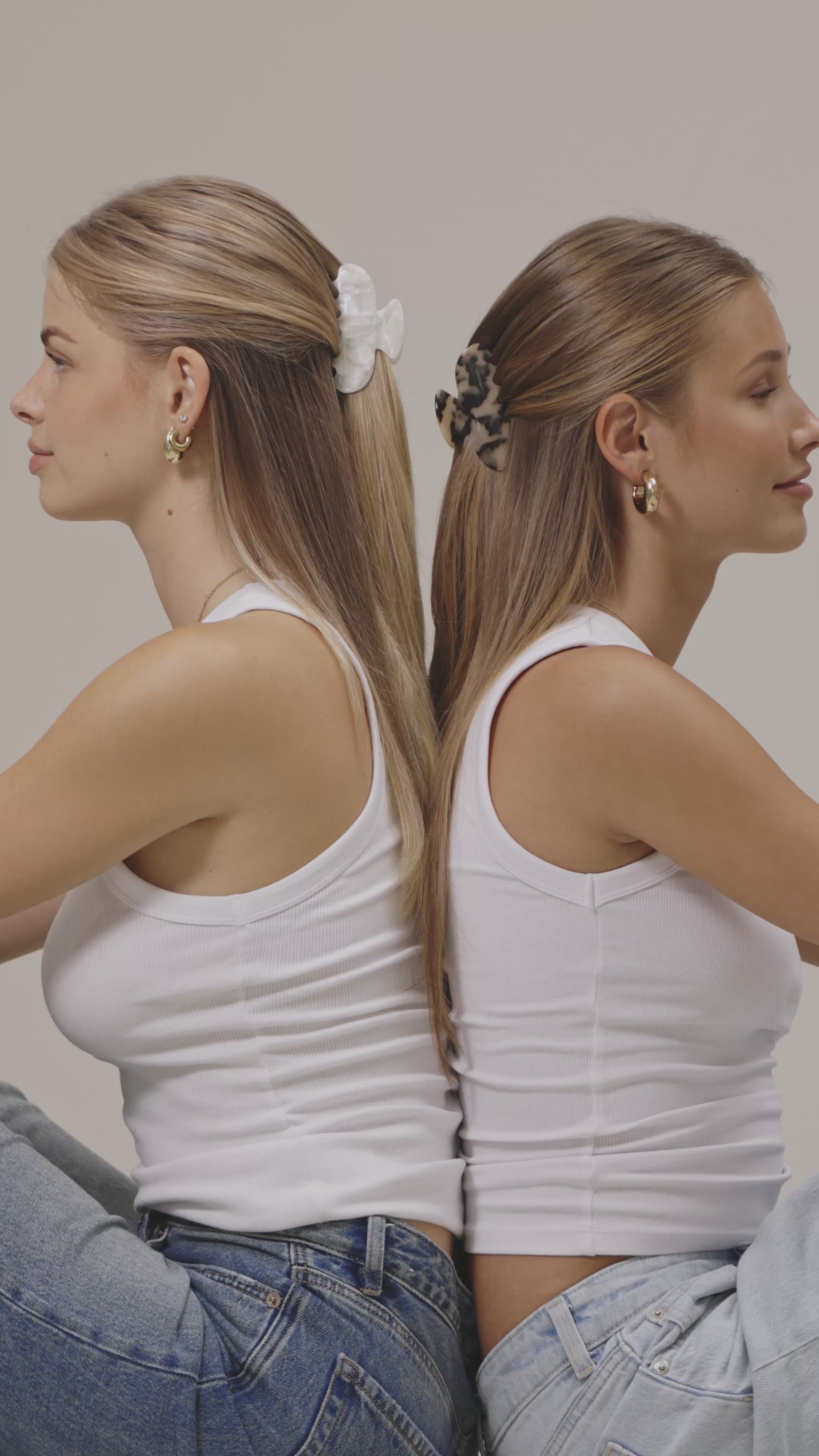 Nahaufnahme: Eine Frau steckt sich eine transparente Gillie-Haarklammer ins hochgesteckte Haar. Die Bewegung ist ruhig und zeigt die einfache Handhabung und den festen Halt der Klammer.